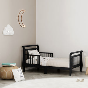 black toddler bed with guardrails in nursery