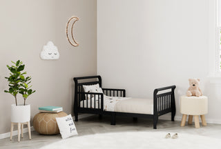 black toddler bed with guardrails in nursery
