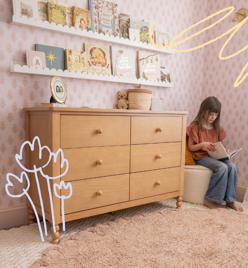 Contact Us Storkcraft. Image of toddler reading book in bedroom next to dresser.