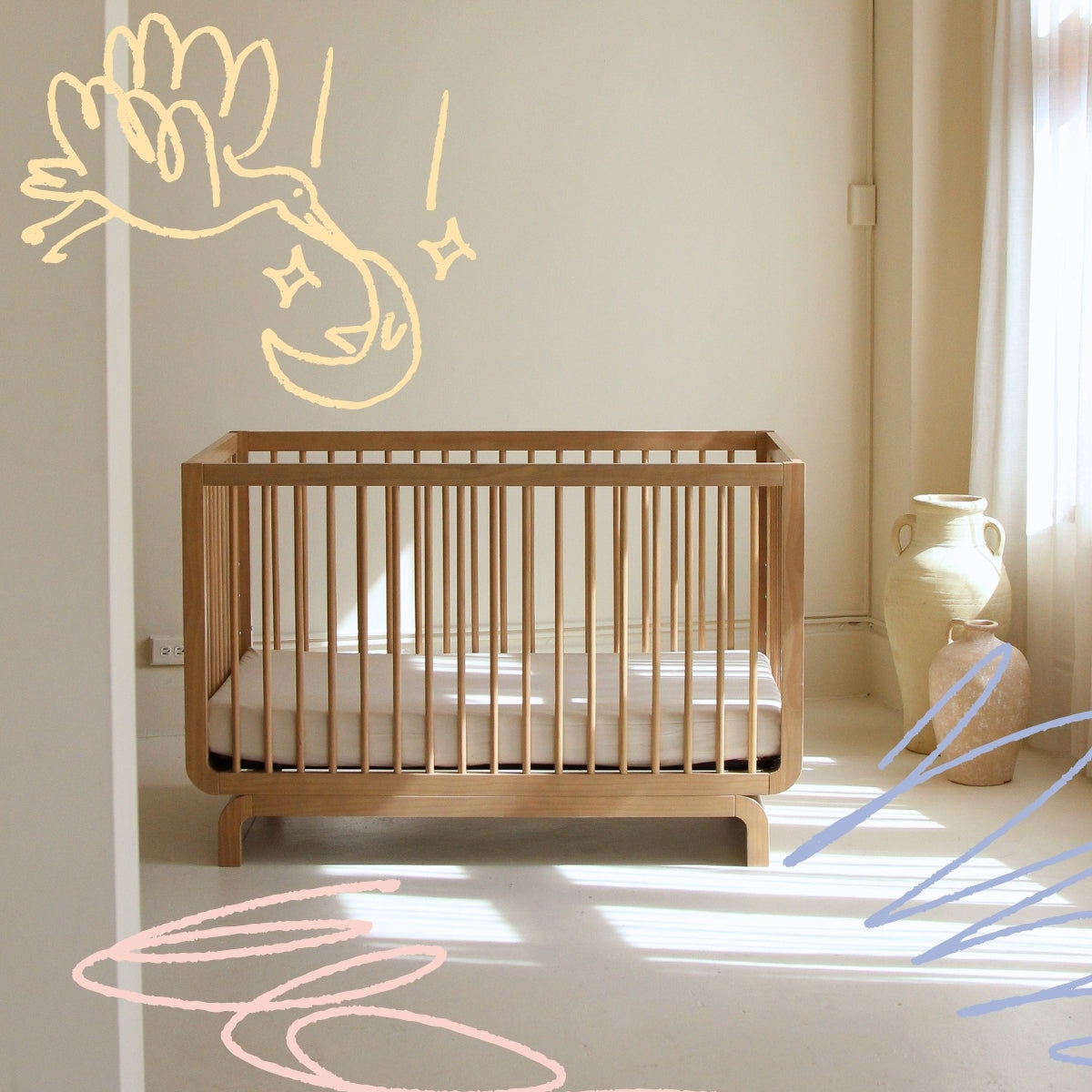 Crib styled in sunlit nursery and room with doodles around.