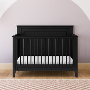 black crib with dowels and solid headboard in nursery