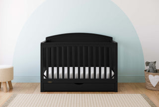 Convertible black crib in a nursery