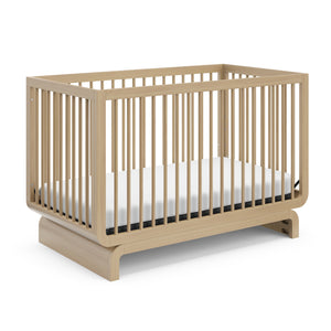 Baby crib in natural wood colorway, at an angle
