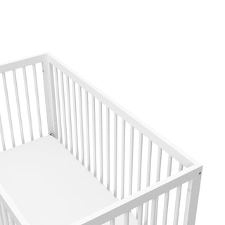 Birds-eye angled view of white baby crib