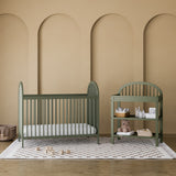 Olivia olive crib in a nursery next to changing table