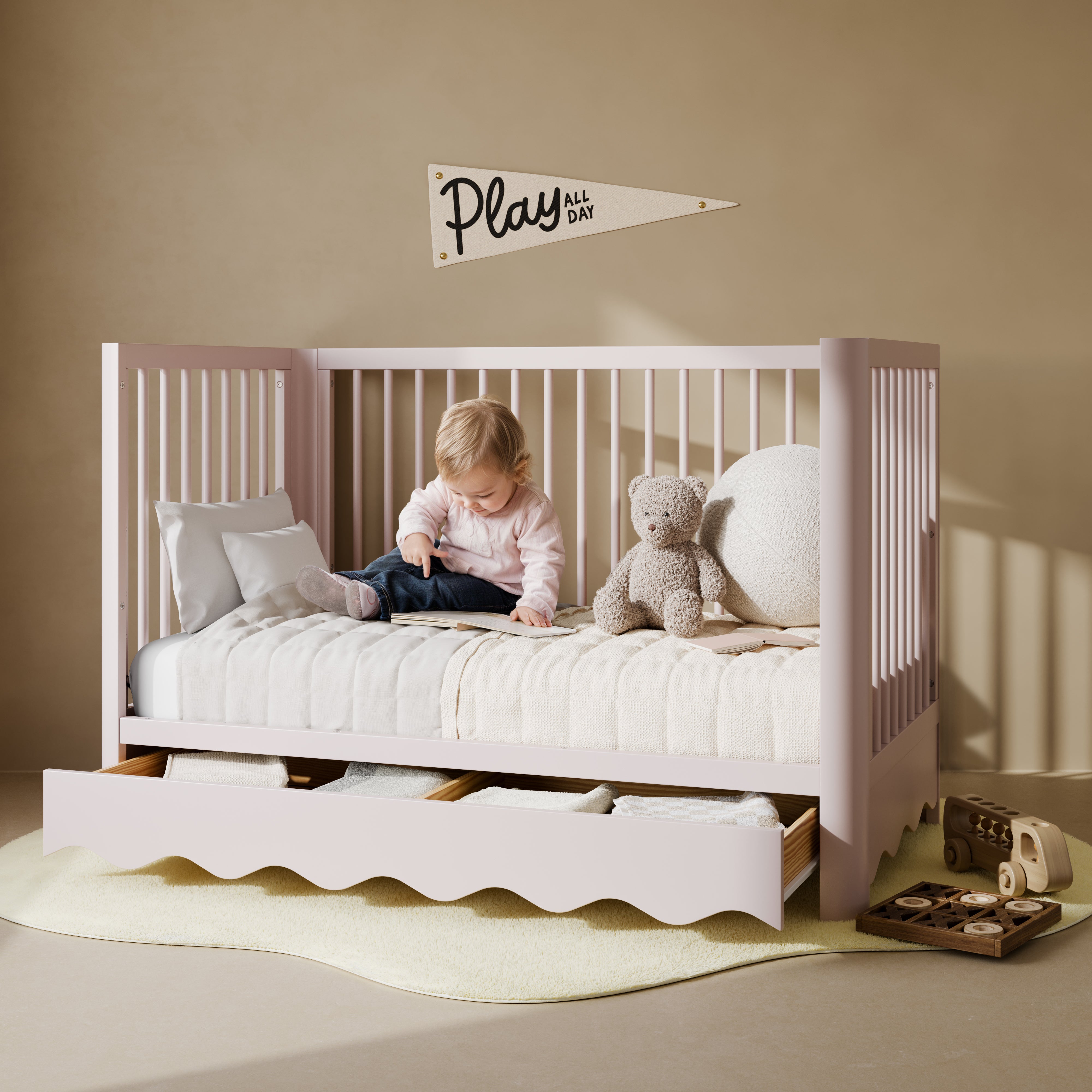 Casablanca blush crib with drawer converted to daybed with child on it nursery