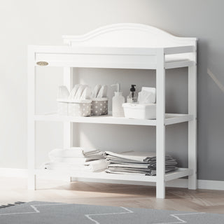 White changing table with storage in nursery 