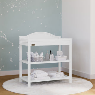 White changing table with storage in nursery 