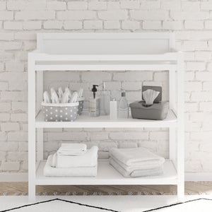 White changing table with storage in nursery 