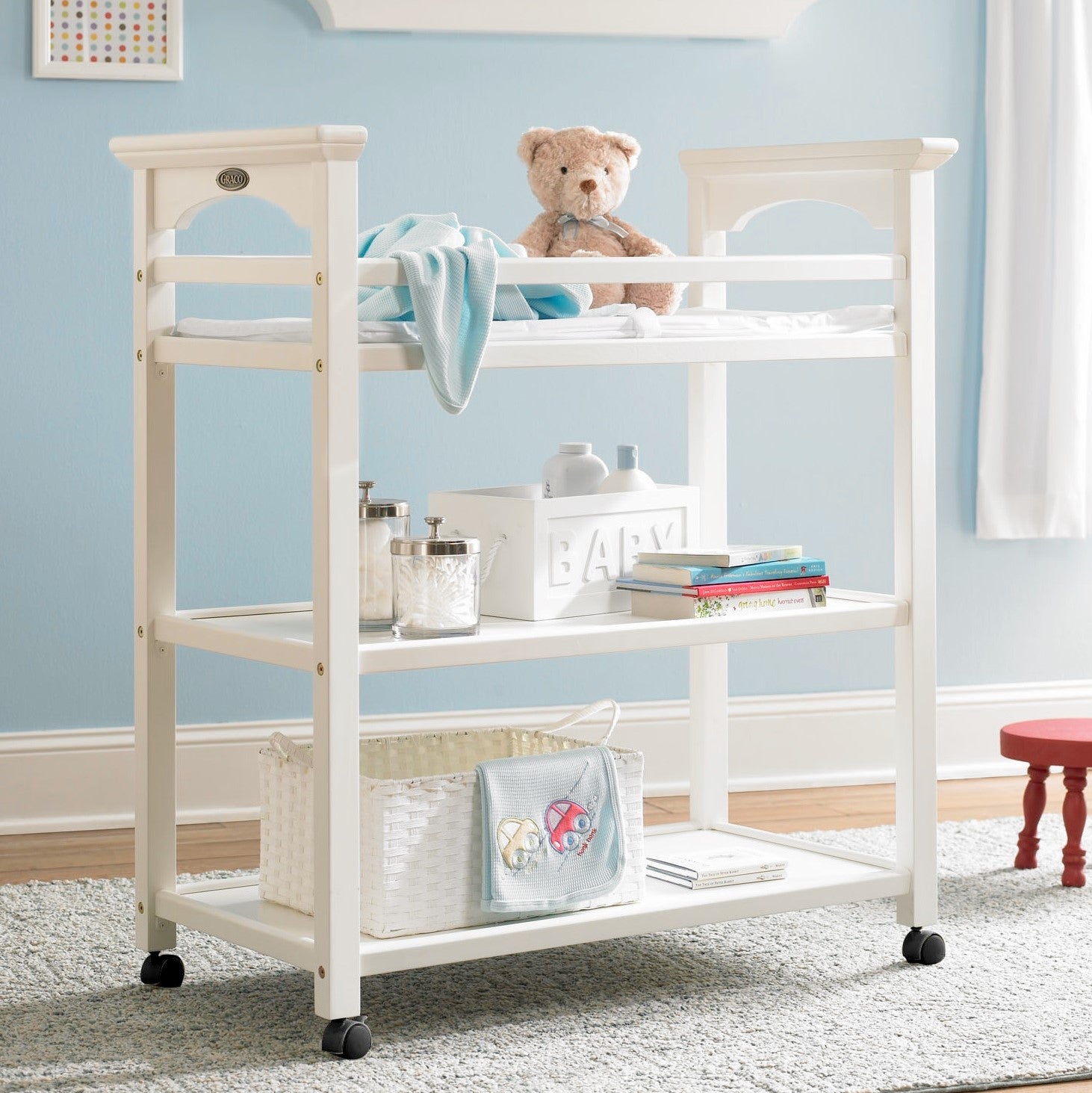 White changing table with two open shelves in nursery 