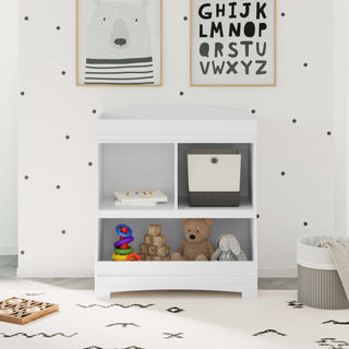 White changing table with storage in nursery 