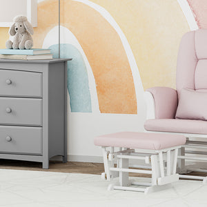 white glider and ottoman with pink swirl cushions in nursery with 6 drawer dresser 