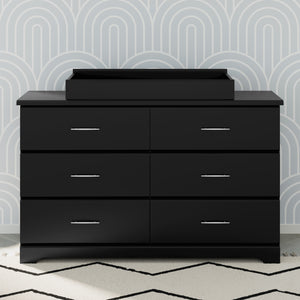 black changing topper on top of 6 drawer dresser in nursery 