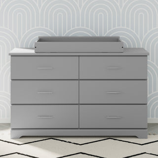 pebble gray changing topper on top of 6 drawer dresser in nursery 