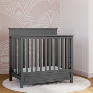 gray mini crib in nursery 