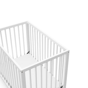 close-up view of white mini crib's headboard