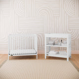 white mini crib in nursery