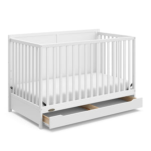 white crib with open drawer