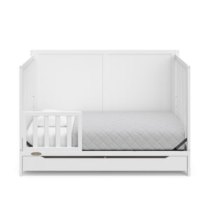 white crib with drawer in toddler bed conversion with one toddler safety guardrail