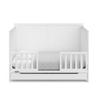 white crib with drawer in toddler bed conversion with two toddler safety guardrails