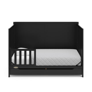 black crib with drawer in toddler bed conversion with one toddler safety guardrail