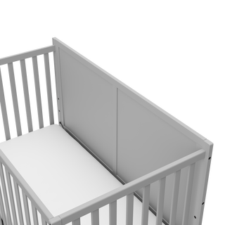 close-up view of pebble gray crib with drawer's headboard
