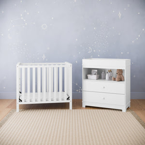 white chest with changing topper in nursery with matching crib