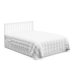 White crib in full-size bed with headboard conversion