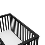 Close-up view of black crib's headboard