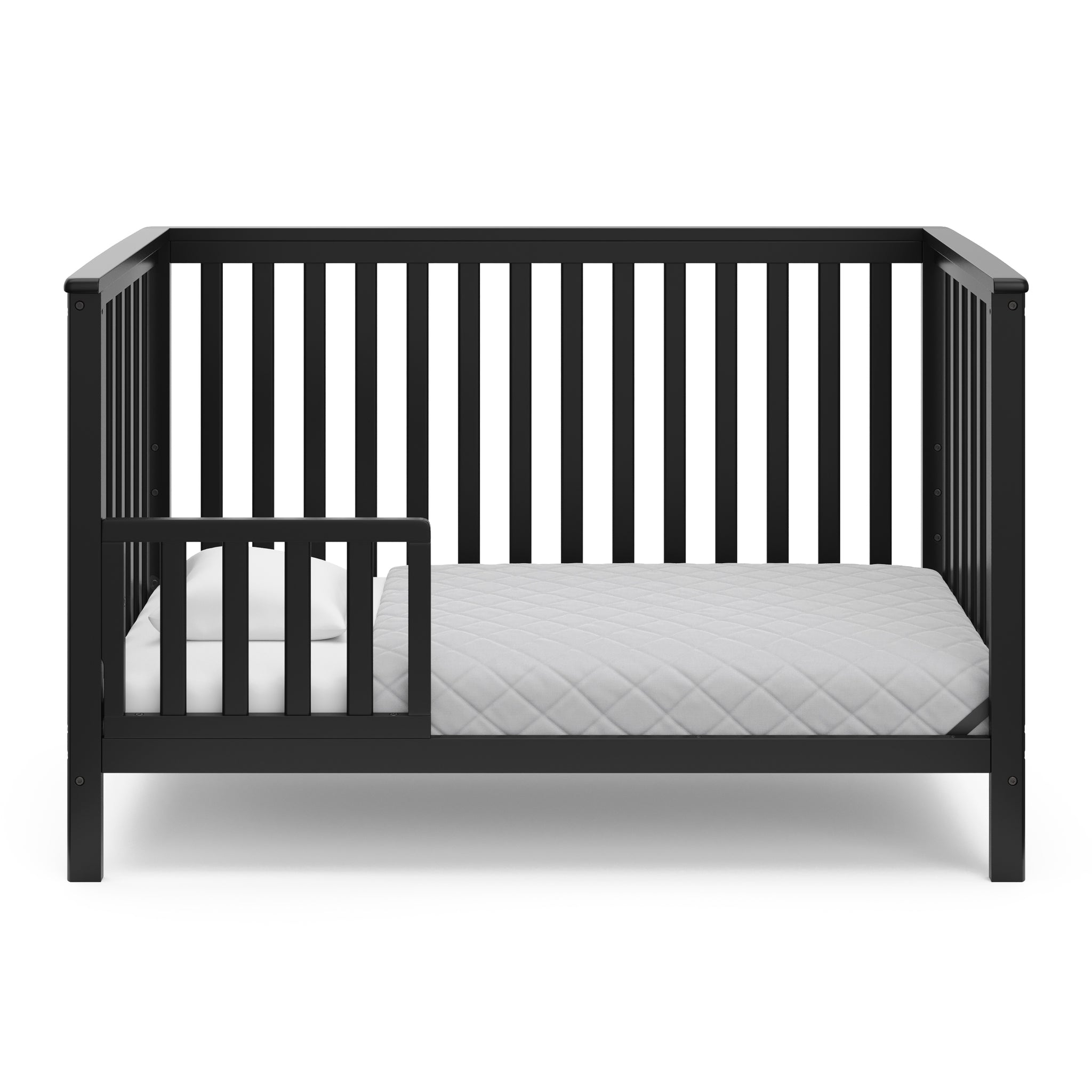 Black crib in toddler bed conversion with one safety guardrail