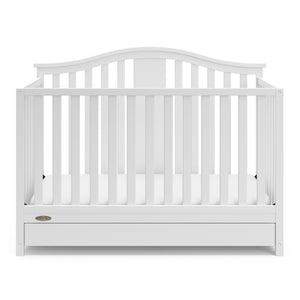 Front view of white crib with drawer