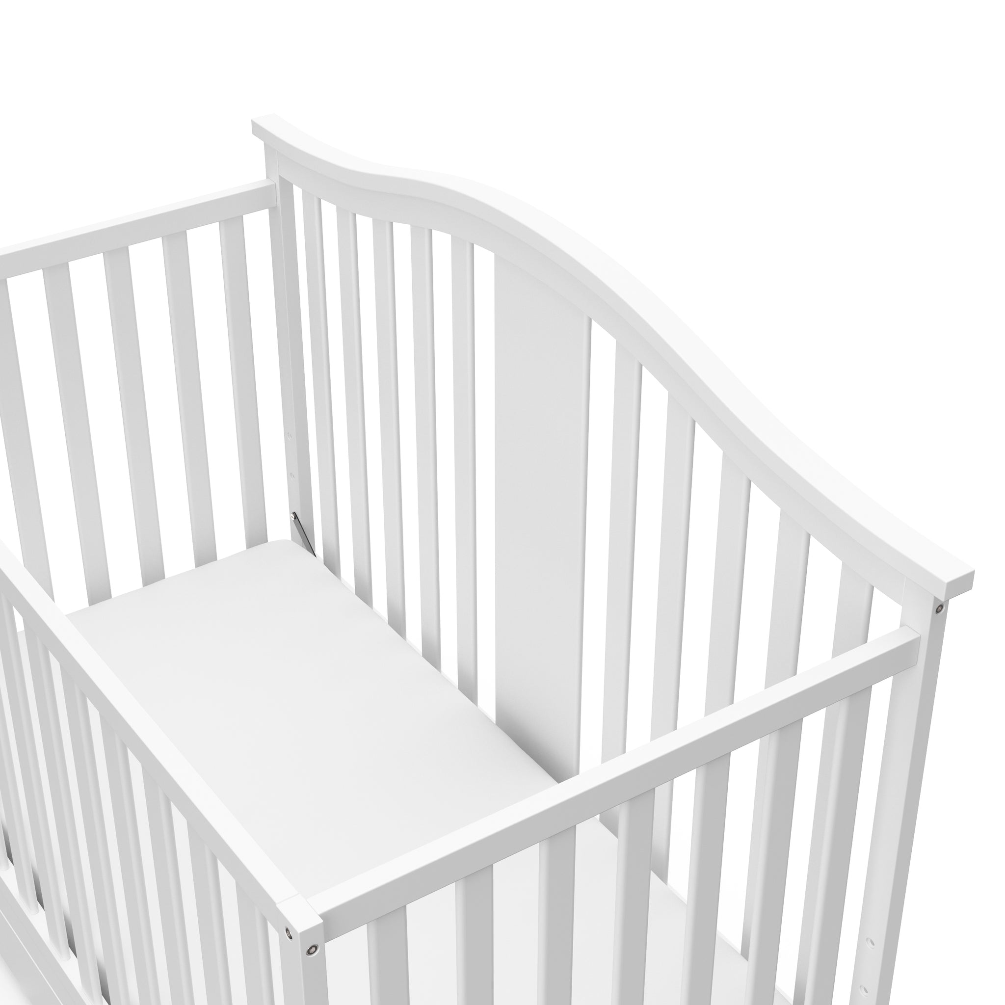 Close-up view of white crib with drawer