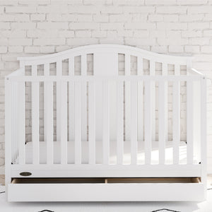 White crib with drawer in nursery