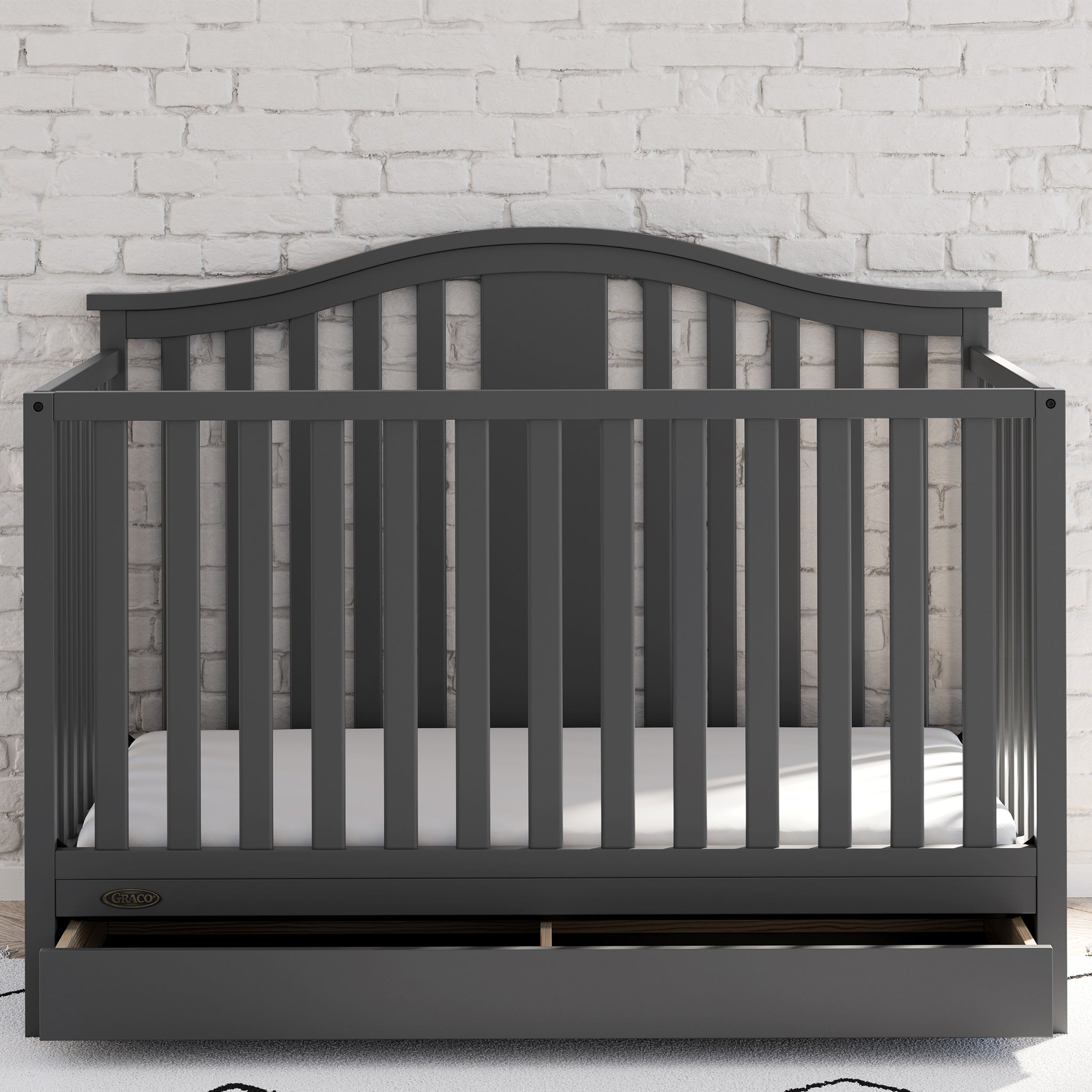 gray crib with drawer in nursery