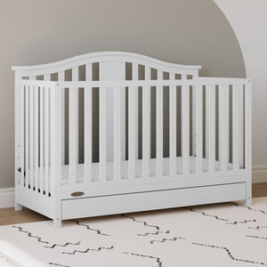 White crib with drawer in nursery