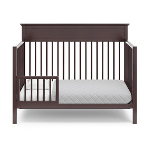 espresso crib in toddler bed conversion with one safety guardrail