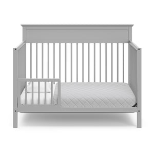 pebble gray crib in toddler bed conversion with one safety guardrail