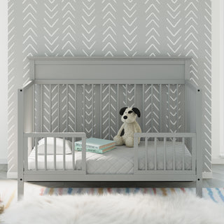 Pebble gray crib in toddler bed conversion with guardrails in nursery