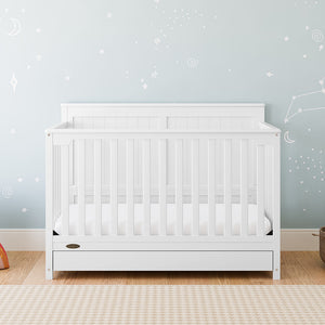 white crib with drawer in nursery