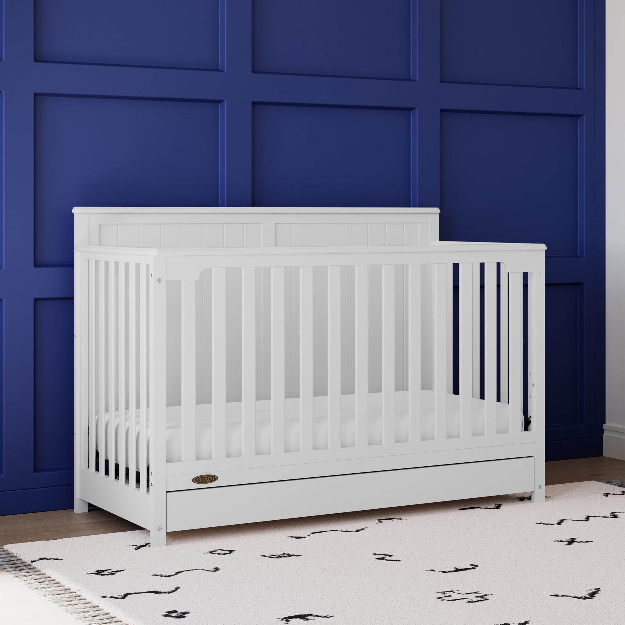 white crib with drawer in nursery