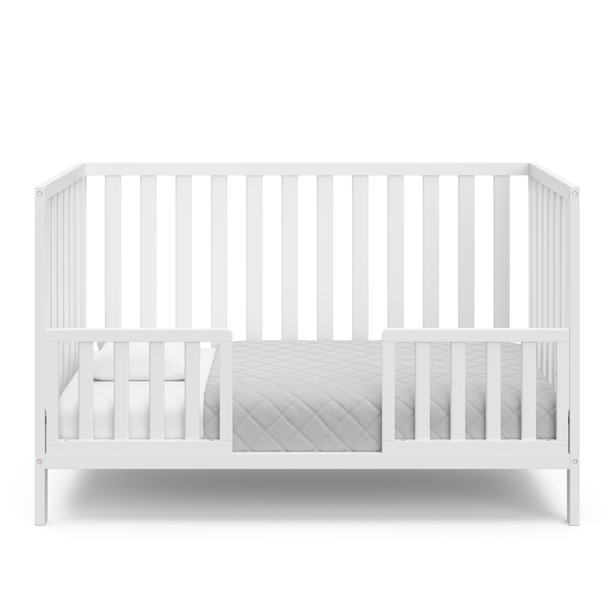 White crib in toddler bed conversion with two safety guardrails