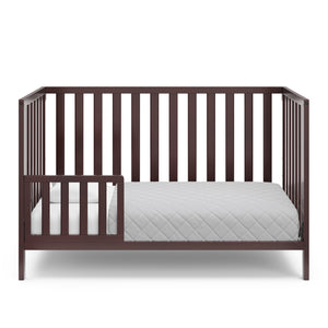 espresso crib in toddler bed conversion with one safety guardrail