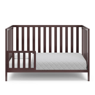 espresso crib in toddler bed conversion with one safety guardrail