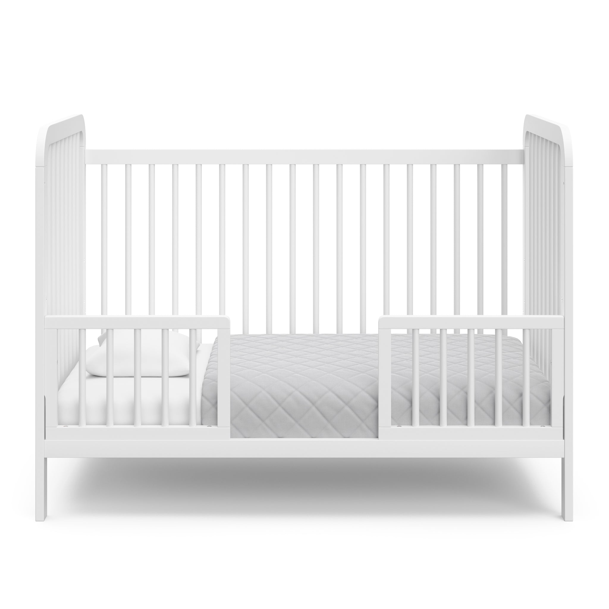 White crib in toddler bed conversion with two safety guardrails 