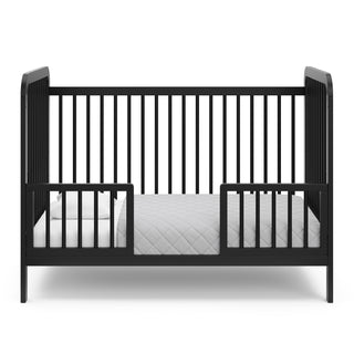 Black crib in toddler bed conversion with two safety guardrails 