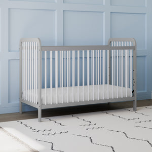Front view of white crib with pebble gray in nursery 