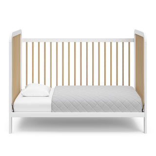 White crib with driftwood in toddler bed conversion 