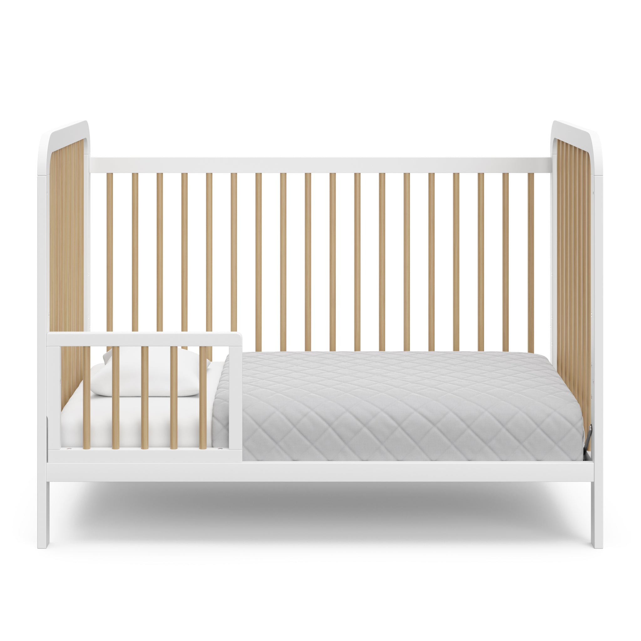 White crib with driftwood in toddler bed conversion with one safety guardrail 