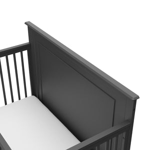 Close-up view of gray crib's headboard 