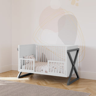 white and gray crib in toddler bed conversions with two toddler safety guardrails, in a nursery